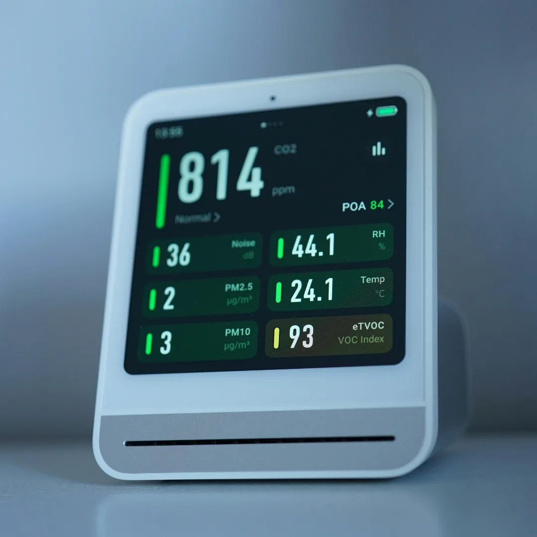 Indoor air quality monitor displaying CO2, humidity, PM2.5, and VOC readings